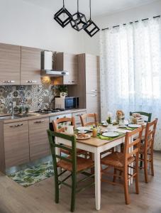 a kitchen with a wooden table and chairs in a kitchen at S'Ilixi in Quartucciu
