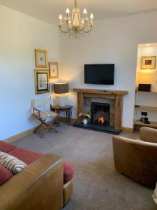 a living room with a fireplace and a television at 8 The Loan in Lauder