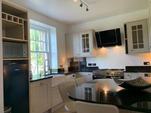 a kitchen with white cabinets and a black counter top at 8 The Loan in Lauder