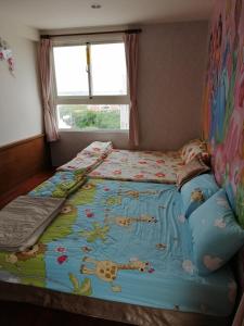 馬公市的住宿－情定海豚灣民宿，一间卧室配有一张带毯子的床和窗户