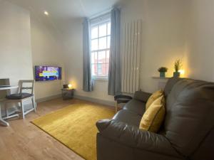 a living room with a couch and a television at Avenham Apartments in Preston