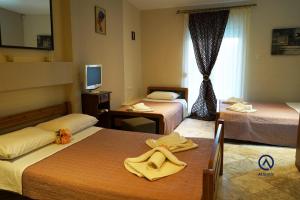 a hotel room with two beds with towels on them at Hotel Atlantis in Nea Kallikrateia