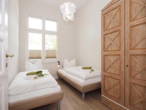 1 dormitorio con 2 camas y una gran puerta de madera en Villa Lucie Else 06, en Heringsdorf