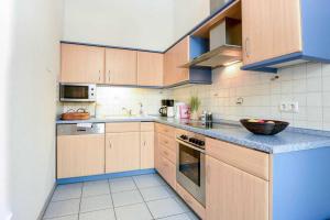 ヘリングスドルフにあるVilla Sanssouci Wohnung 5のキッチン(木製キャビネット、青いカウンタートップ付)