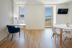 a living room with a table and chairs and a dining room at Hotel SANSEbay in Donostia-San Sebastián