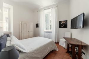 ローマにあるB&B ドムズ クィリタムのベッドルーム1室(ベッド1台、壁掛けテレビ付)