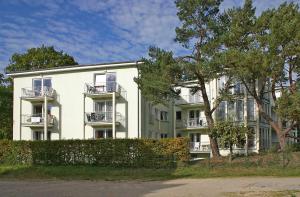 un grande edificio bianco con balconi e alberi di Haus Strandoase 23 a Bansin