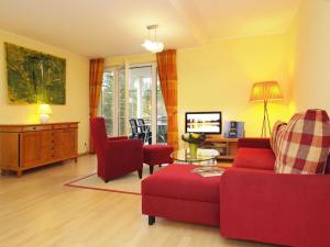ヘリングスドルフにあるVilla Darja Wohnung 9のリビングルーム(赤いソファ、椅子付)