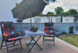 two chairs and a table with an umbrella on a patio at Bungalow Ostend in Ahlbeck