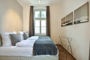 um quarto com uma cama com um cobertor azul em Villa Medici Wohnung 6 em Heringsdorf