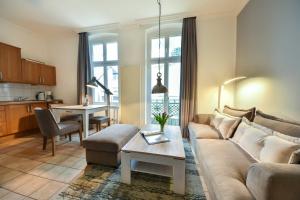 uma sala de estar com um sofá e uma mesa em Villa Medici Wohnung 6 em Heringsdorf