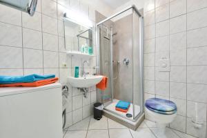 uma casa de banho com um chuveiro, um WC e um lavatório. em Haus Dünenweg 01 em Heringsdorf