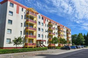 um grande edifício com varandas coloridas num parque de estacionamento em Haus Dünenweg 01 em Heringsdorf