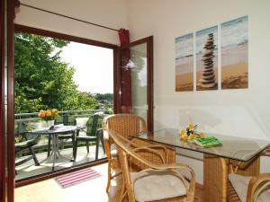 a balcony with a glass table and chairs and a patio at Haus auf der Höhe - Panorama in Heringsdorf