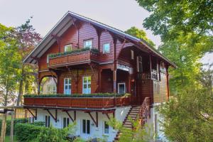 ヘリングスドルフにあるOstseepark Captain`s Haus 1 4の木造の家屋で、バルコニーが付いています。