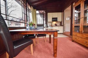 a dining room with a wooden table and a kitchen at Ostseepark Captain`s Haus 1 4 in Heringsdorf