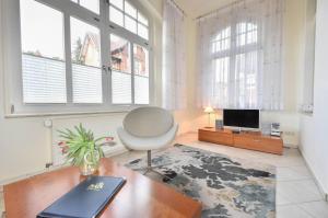 ein Wohnzimmer mit einem Schreibtisch, einem Stuhl und einem TV in der Unterkunft (14b) Villa Emmy 02 in Heringsdorf