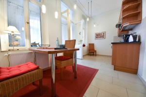 Zimmer mit einem Tisch, Stühlen, einem Tisch und Fenstern in der Unterkunft (14b) Villa Emmy 02 in Heringsdorf