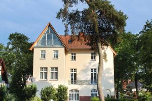 ein großes weißes Haus mit einem roten Dach in der Unterkunft (14b) Villa Emmy 02 in Heringsdorf