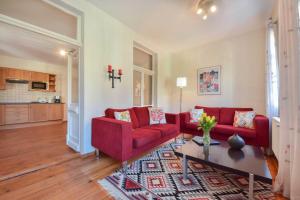 uma sala de estar com dois sofás vermelhos e uma mesa em Villa Emmy Wohnung 8 em Heringsdorf