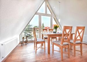 d'une salle à manger avec une table, des chaises et une fenêtre. dans l'établissement Villa Emmy Wohnung 9, à Heringsdorf