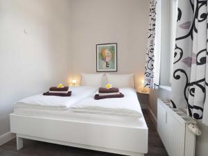 ヘリングスドルフにあるVilla Lucie Else 01のベッドルーム1室(白いベッド1台、キャンドル2本付)
