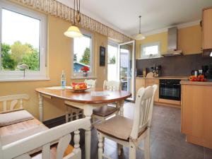 uma cozinha e sala de jantar com uma mesa de madeira e cadeiras em Inselhaus Heringsdorf EG em Heringsdorf
