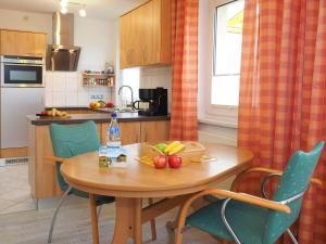 - une cuisine avec une table en bois et des fruits dans l'établissement Haus Dünenweg 28, à Heringsdorf