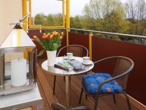 d'une petite table et de chaises sur un balcon fleuri dans l'établissement Haus Dünenweg 28, à Heringsdorf