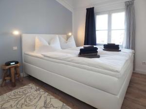 a large white bed in a room with a window at Villa Vineta Wohnung 206 in Ahlbeck