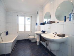 a bathroom with two sinks and a tub and a toilet at Villa Vineta Wohnung 206 in Ahlbeck