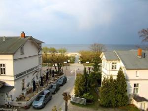 a building with cars parked in front of a street at Villa Vineta Wohnung 206 in Ahlbeck +2 photos