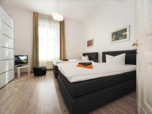 ヘリングスドルフにあるVilla Elisabeth Wohnung Welleのベッド2台とテレビが備わるホテルルームです。