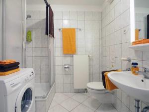 een badkamer met een wasmachine en een wastafel bij Haus Dünenweg 29 in Heringsdorf