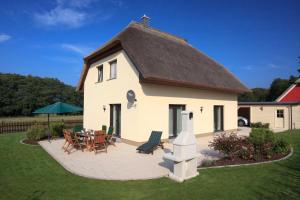 a large white house with a table and chairs at Ferienhaus Seestrand - mit Sauna in Kolpinsee