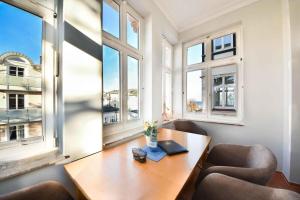 アールベックにあるVilla Vineta Wohnung 203のテーブルと椅子2脚、窓が備わる客室です。