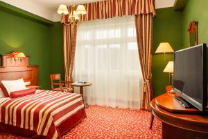 a hotel room with a bed and a television at Spa Hotel Imperial in Karlovy Vary