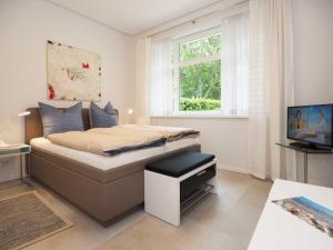 Un dormitorio con una cama con televisión y una ventana. en Ferienhaus Kleines Palais, en Heringsdorf