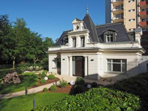 Una casa blanca con una torre de reloj encima. en Ferienhaus Kleines Palais, en Heringsdorf