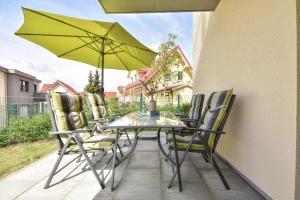 un tavolo da patio con sedie e ombrellone verde di Sonnenpark 02 a Korswandt