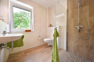 La salle de bains est pourvue d'une douche, d'un lavabo et de toilettes. dans l'établissement Sonnenpark 04, à Korswandt