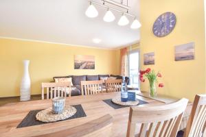 - une salle à manger et un salon avec une table et des chaises dans l'établissement Sonnenpark 04, à Korswandt