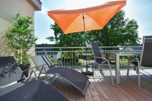 un parasol orange assis au-dessus d'une terrasse dans l'établissement Sonnenpark 08, à Korswandt