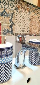 阿奇雷亞萊的住宿－Antica Dimora Barocca，浴室水槽配有蓝色和白色的瓷器餐具