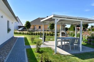 einen Tisch und Stühle unter einem Pavillon im Hof in der Unterkunft Achterwasser 01 in Pudagla