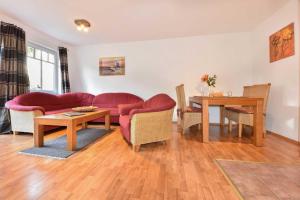 - un salon avec un canapé rouge et une table dans l'établissement Appartement Steinersberg 4, à Heringsdorf