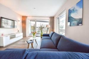黑靈斯多夫的住宿－Haus Seven Seas - Wohnung Pazifik，客厅设有蓝色的沙发和大窗户