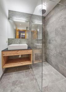 y baño con lavabo y ducha. en Delfi Ski & Bike Appartements, en Saalbach Hinterglemm