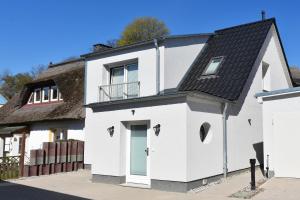 KamminkeにあるFerienhaus Insel-Paradiesの茅葺き屋根の白屋敷