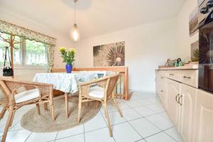 uma sala de jantar com uma mesa e cadeiras numa cozinha em Ferienwohnung Salamander em Bansin